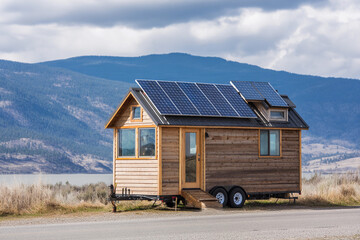 Tiny house with solar panels near scenic mountains