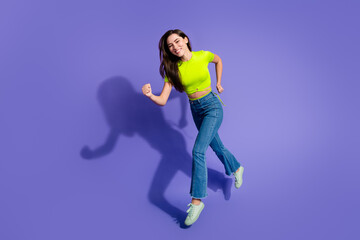 Young woman in stylish casual attire joyfully posing against a violet background exuding energy, positivity, and summer vibes