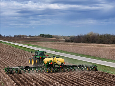 Rockford, Illinois - April 23, 2025: John Deere 410 8R tractor pulling a John Deere 1775NT 24 row planter.