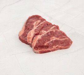 Fresh raw chuck eye steaks on white marble surface ready for cooking – High Resolution Raw Meat Image for Food Industry or Food Packaging