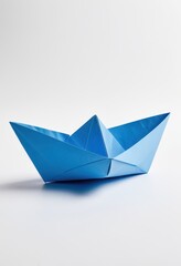 A vibrant blue paper boat symbolizes creativity and childhood memories. Perfect for artsy backgrounds.