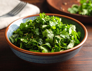 A mound of chopped fresh coriander placed in a ceramic bowl ready for garnish.