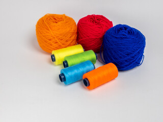 Colorful Yarn Balls and Spools of Thread on a Plain White Background