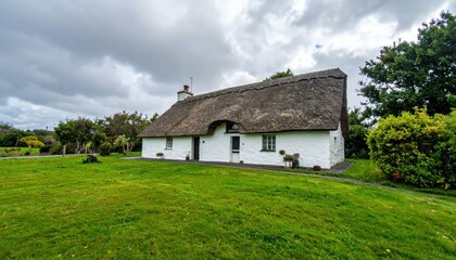 Charming Irish Cottage with Thatched Roof in Lush Green Landscape