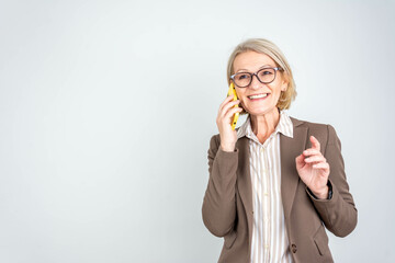 Happy smiling mature middle aged business woman, 50s professional lady executive manager talking on...