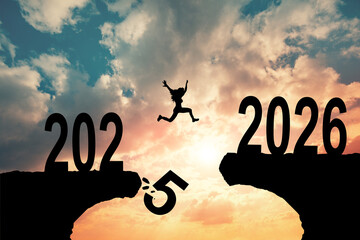 A man jump happy new year 2025 to 2026 concept, silhouette of a man jumping over the sun in sunrise...