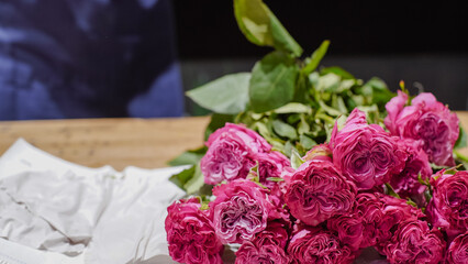 An unpacked package of pink roses lies on a table in a flower shop. bouquet of roses. Small business.   Close-Up.