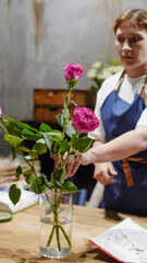 A florist makes a bouquet of pink roses in a flower shop. Small business.  Close-Up.