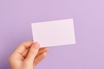 Obraz premium delicate hand holding simple thank you card against plain pastel background provides minimalist aesthetic with ample