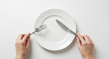 Empty plate with hands holding fork and knife on white background, top view