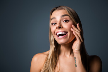 Fototapeta premium Young woman with radiant smile and natural beauty in studio portrait, highlighting elegance and gentle charm