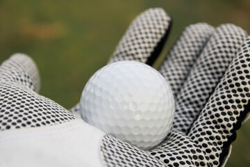 Close-Up of Golf Ball in Player's Hand Wearing Sport Glove