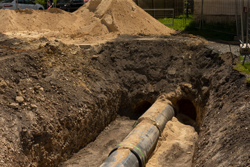 The excavation process prominently showcases the installation of a pipeline at the active...