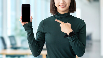 スマートフォンを指差す女性・ビジネスウーマン