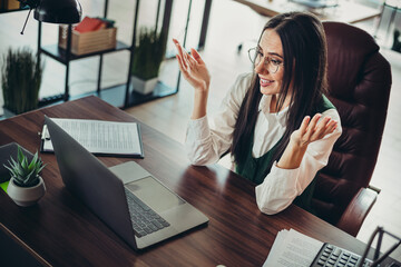 Confident businesswoman in modern office workspace having a virtual meeting and expressing ideas...