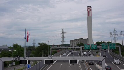 High angle view of multi lane highway A1 with chimney of heating plant at Swiss City of Zürich on a cloudy spring day. Movie shot May 21st, 2025, Zurich Schwamendingen, Switzerland. - Powered by Adobe