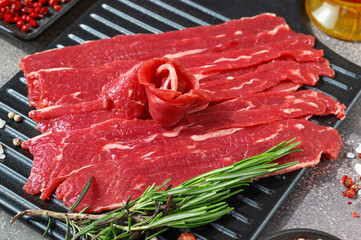 Cooking thinly sliced beef accompanied by colorful spices and herbs. Preparing carpaccio