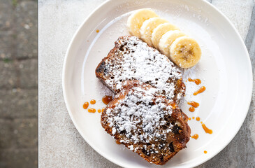 Banana bread cake with power sugar on a white plate in Brasschaat, Antwerp, Belgium