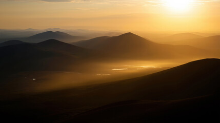 Golden sunrise over rolling hills and misty valleys in a tranquil landscape