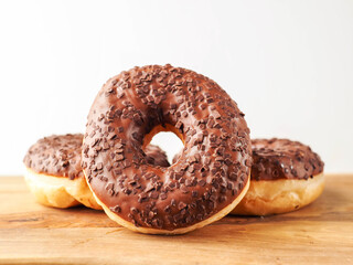 Sweet tasty chocolate donuts on wooden board. Popular desert and snack. Fine bakery product.
