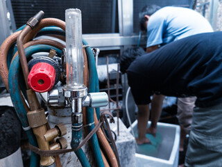 A technician is repairing the refrigerant pipe welding process on a chiller compressor machine.