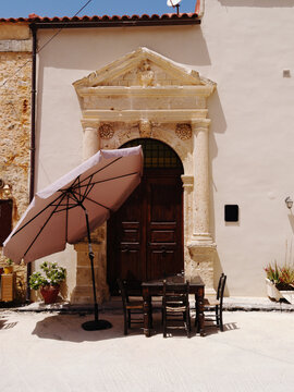 Crete island, Greece. Ornate Venetian doorway in Amnatos village, near Rethymnon. Elegant carved stonework. Bright summer day in a charming beautiful small town.