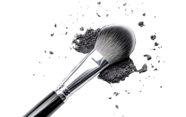 Makeup brush is laying on a white surface with a pile of black powder on it