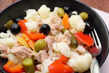Ravvicinato di un piatto di cavolo bianco in insalata condito con olive, sottaceti, e tonno