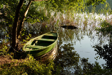 wooden boat moored to the lake shore
