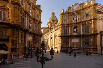 Fototapeta premium People stroll through Quattro Canti square in Palermo as golden light illuminates the baroque facades. This photo captures architectural elegance and the charm of urban exploration in Sicily