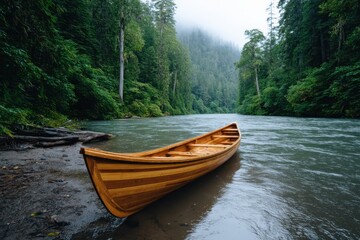 Fototapeta premium Wooden canoe resting on the riverbank with lush green trees surrounding the waterway