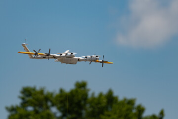 Close up of a drone in flight isolated against a blue sky with copy space