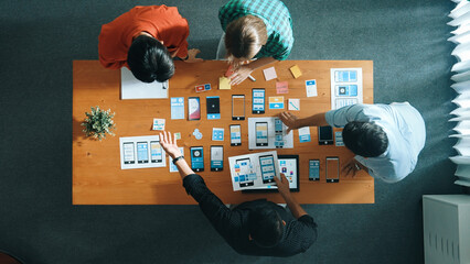 Creative team sitting and discussing while brainstorm about Ux Ui design mobile phone interface. People planning strategy start up project while planning a strategy at business meeting. Convocation.