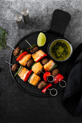 salmon skewers with vegetables and green sauce. summer barbecue recipe