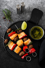 salmon skewers with vegetables and green sauce. summer barbecue recipe
