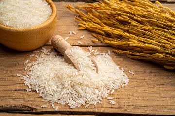 Heap of Uncooked white jasmine rice on wooden table