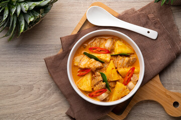Thai Red curry Pineapple with Sliced Pork Belly in white bowl.Top view