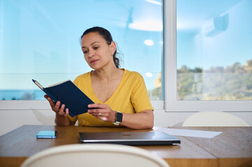 Woman Reading Notebook in Minimalist Home Office on a Sunny Day