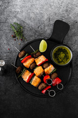 salmon skewers with vegetables and green sauce. summer barbecue recipe