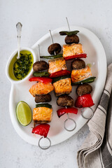 salmon skewers with vegetables and green sauce. summer barbecue recipe