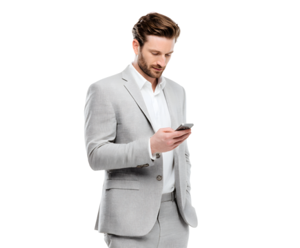 A well-dressed man in a gray suit intently checks his smartphone in a professional setting.