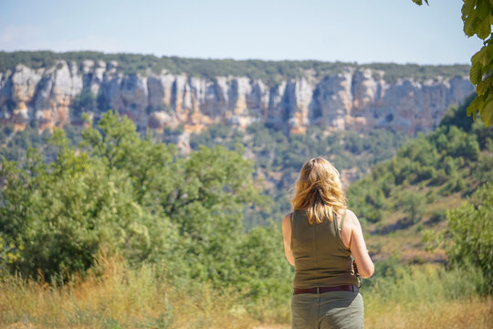 Young woman wearing a T-shirt and shorts contemplating the landscape and vegetation of the province of Burgos