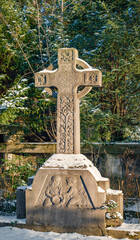 Ornamentgeschmücktes historisches Grabkreuz auf dem winterlichen "Friedhof III der Jerusalems- und Neuen Kirchengemeinde" in Berlin-Kreuzberg
