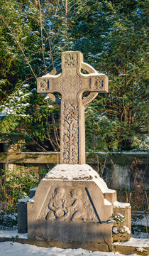 Ornamentgeschm&uuml;cktes historisches Grabkreuz auf dem winterlichen "Friedhof III der Jerusalems- und Neuen Kirchengemeinde" in Berlin-Kreuzberg