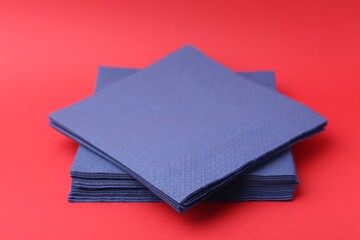 Stack of blue handkerchiefs on red background, closeup
