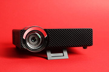 Modern video projector on red background, closeup