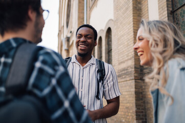 Happy students talking and laughing together outdoors