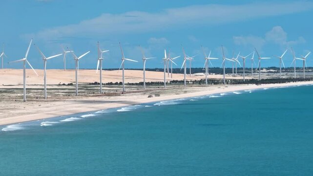 Aeolian Park In Canoa Quebrada Beach Ceara Brazil. Wind Turbine Generating Clean Energy On A Sunny Day. Shore Clouds Beach Sea. Outside Beach Panning Wide. Canoa Quebrada Beach Ceara.