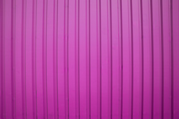 Vertical ribbed pink metal surface with light shadowing, perfect for modern industrial backgrounds or design use.