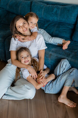 Mom and daughters playing at home on the couch